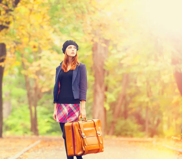 Redhead girl with suitcase at autumn outdoor. — Stock Photo, Image