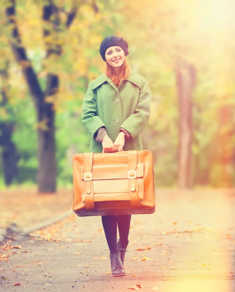 Redhead girl with suitcase at autumn outdoor. — Stock Photo, Image