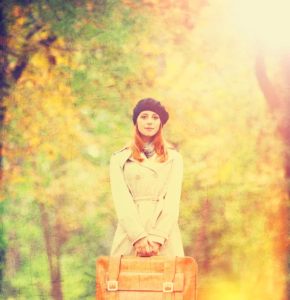 Pelirroja con maleta en otoño al aire libre . — Foto de Stock