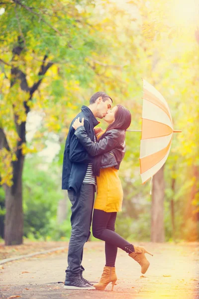 Couplewith umbrella kissing outdoor in the park — Stock Photo, Image