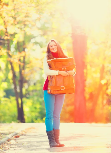 Teenie-Mädchen mit Koffer im Herbst im Freien — Stockfoto