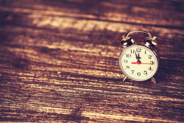 Reloj despertador retro sobre fondo de madera — Foto de Stock