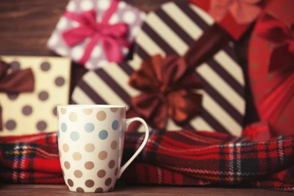 Winter tea in a cup and christmas gifts on background. — Stock Photo, Image