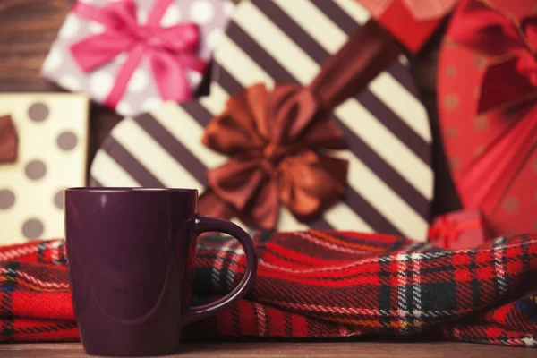 Winter tea in a cup and christmas gifts on background. — Stock Photo, Image