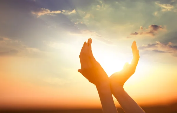 Manos sosteniendo el sol al amanecer — Foto de Stock