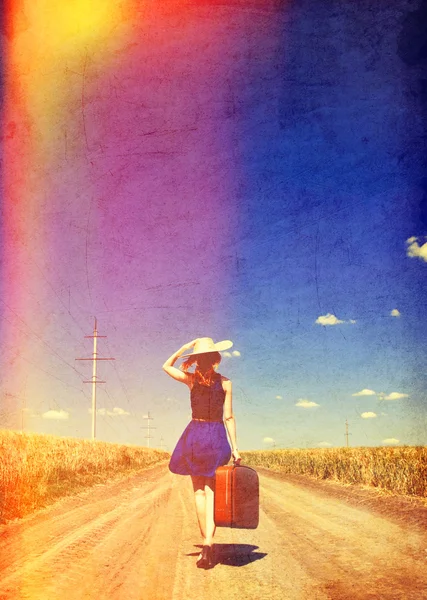 Lonely girl with suitcase at country road. — Stock Photo, Image