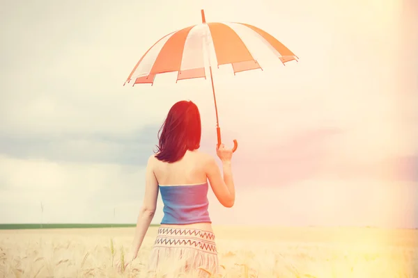 Redhead girl with umbrella at field — Stock Photo, Image