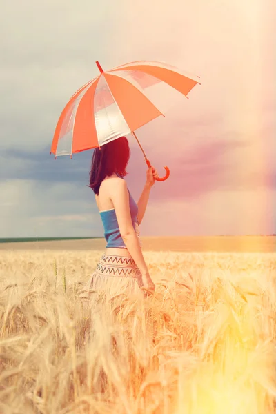Rödhårig tjej med paraply på fältet — Stockfoto