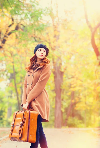 Redhead girl with suitcase at autumn outdoor — Stock Photo, Image
