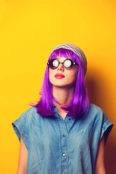Девушка с фиолетовыми волосами в солнцезащитных очках на желтом заднем плане — стоковое фото