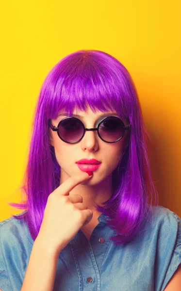 Девушка с фиолетовыми волосами в солнцезащитных очках на желтом заднем плане — стоковое фото