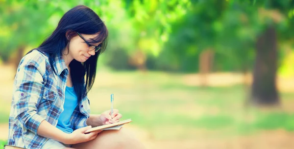 Tiener meisje met laptop in het park. — Stockfoto