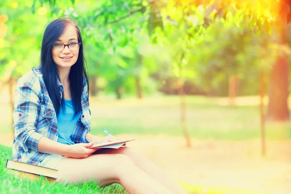 Chica adolescente con cuaderno en el parque . — Foto de Stock