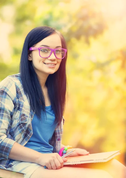 Tiener meisje met laptop in het park. — Stockfoto