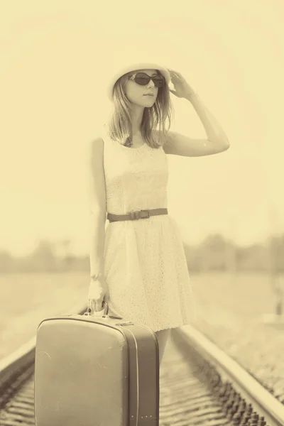 Junges Modemädchen mit Koffer bei der Bahn. — Stockfoto