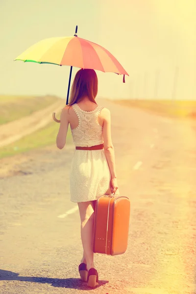 Redhead enchantress walking near rapeseed field. Photo in old im — Stock Photo, Image