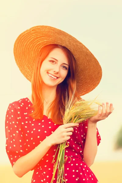 Fille rousse en robe rouge au champ de blé — Photo