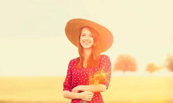 Ragazza rossa in abito rosso al campo di grano — Foto Stock