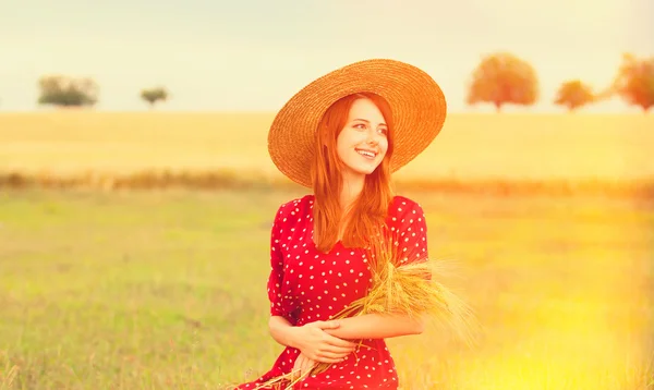 Ragazza rossa in abito rosso al campo di grano — Foto Stock