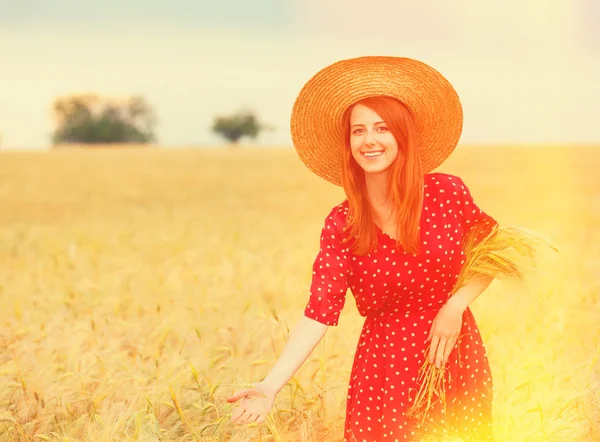 Redhead girl in red dress at wheat field — Stock Photo, Image