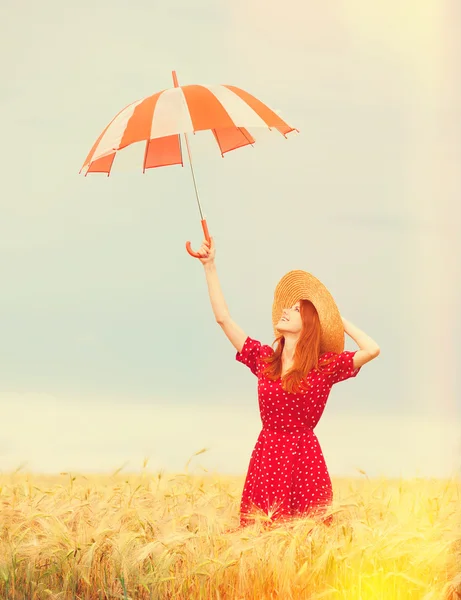 Redhead girl with umbrella at wheat field — Stock Photo, Image