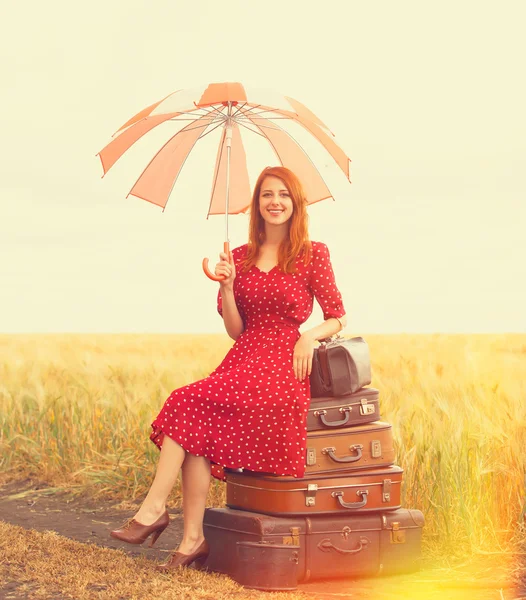 Рыжая девушка с чемоданами на открытом воздухе — стоковое фото
