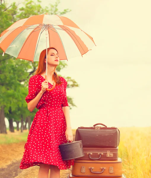 Redhead girl with suitcases at outdoor — Stock Photo, Image