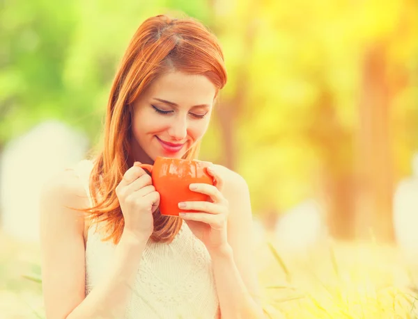 Rödhårig tjej med orange cup på utomhus — Stockfoto