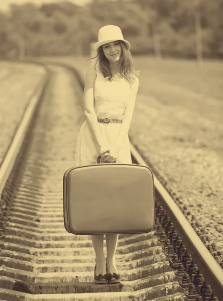 Young fashion girl with suitcase at railways. Stock Picture