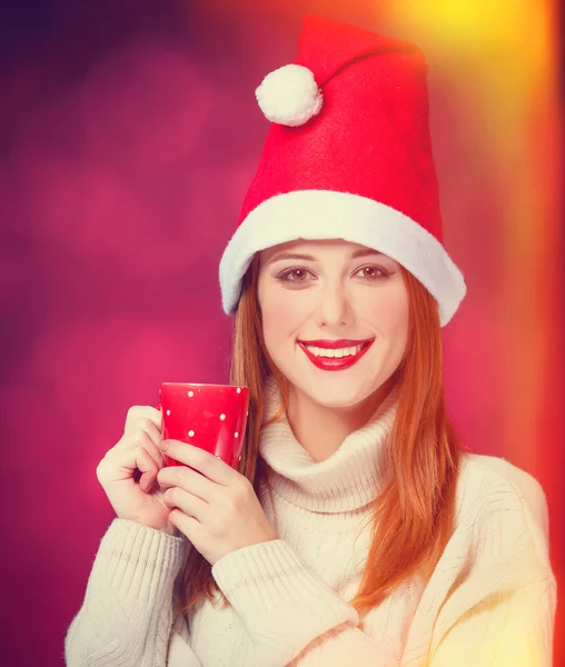 Pelirroja en sombrero de Navidad con taza —  Fotos de Stock