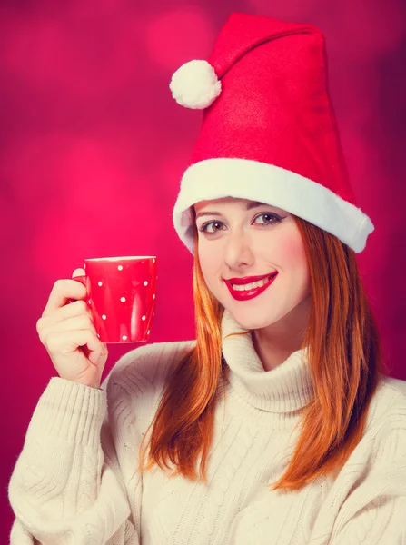 컵 크리스마스 모자에 있는 빨강 머리 소녀 — 스톡 사진