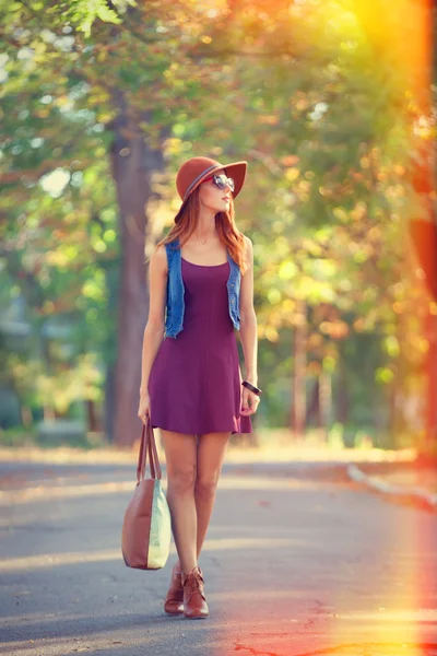 Vacker rödhårig tjej med väska i parken. — Stockfoto