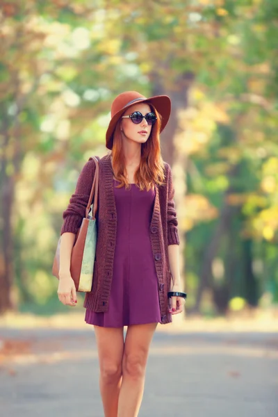 Hermosa pelirroja con bolsa en el parque . — Foto de Stock