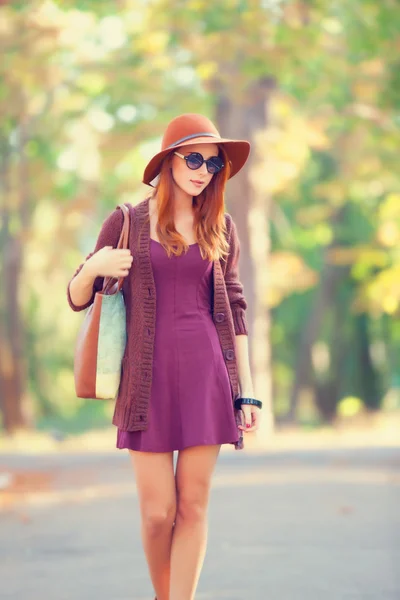 Mooi roodharig meisje met bag in het park. — Stockfoto