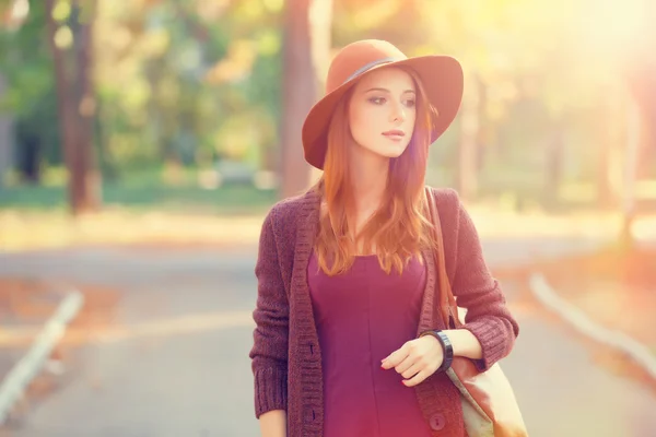 Ragazza rossa in cappello nel parco autunnale . — Foto Stock