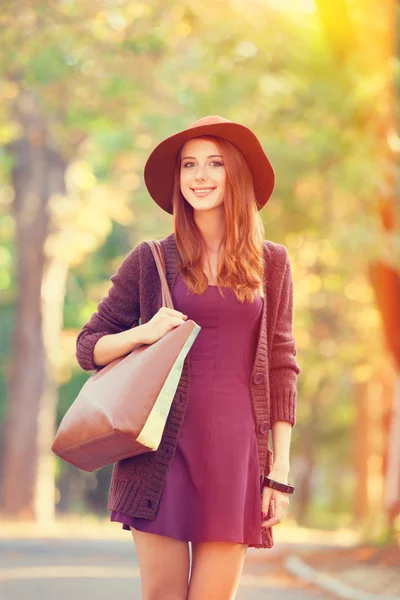 Ragazza rossa in cappello nel parco autunnale . — Foto Stock