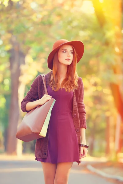 Rödhårig tjej i hatt i höst park. — Stockfoto