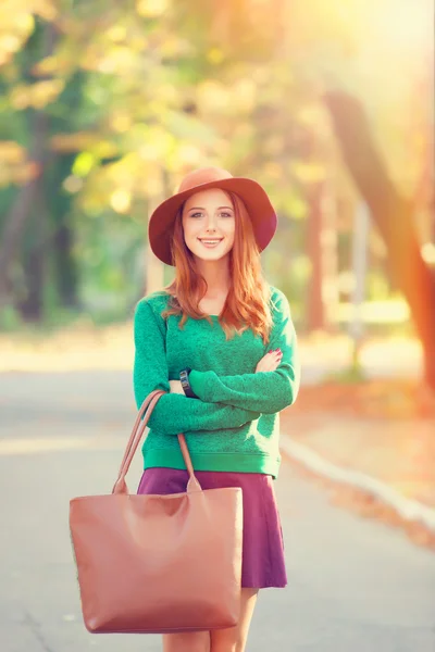 Ragazza rossa in cappello nel parco autunnale . — Foto Stock