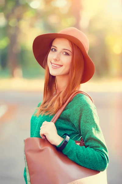 Rödhårig tjej i hatt i höst park. — Stockfoto