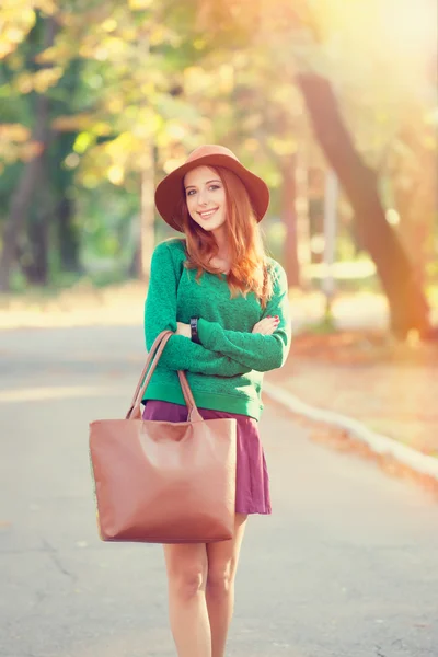 Redhead girl in hat in the autumn park. — Stock Photo, Image