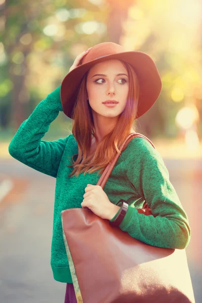 红发女孩戴着帽子在片秋色的公园. — 图库照片