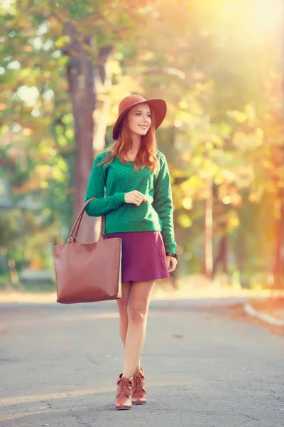 Redhead girl in hat in the autumn park. Stock Image