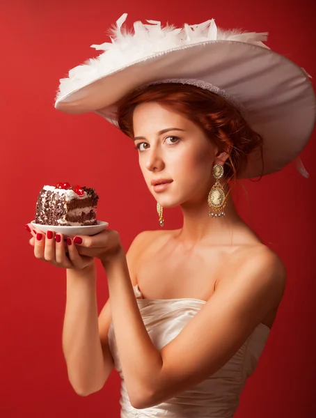 Portret rudy edwardian kobiet z ciasta na czerwonym tle. — Zdjęcie stockowe
