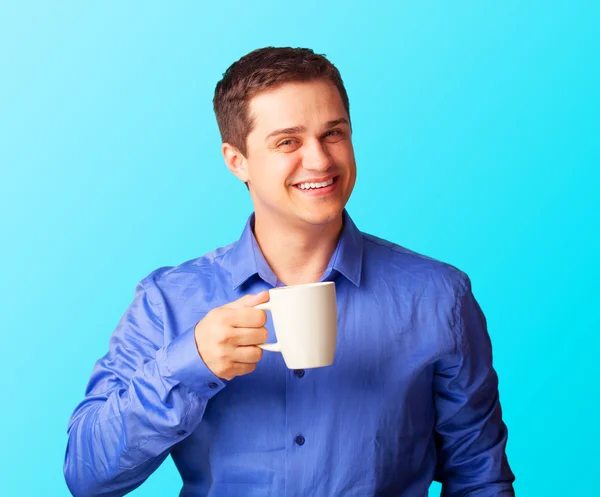 Lässiger Mann im Hemd mit Tasse auf blauem Hintergrund. — Stockfoto