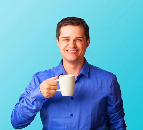 Lässiger Mann im Hemd mit Tasse auf blauem Hintergrund. — Stockfoto