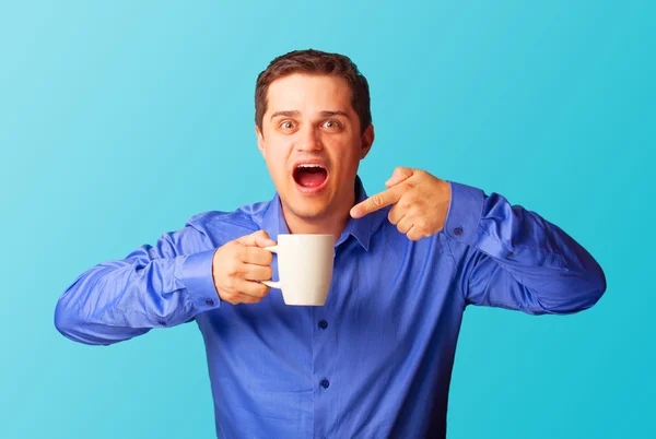 Lässiger Mann im Hemd mit Tasse auf blauem Hintergrund. — Stockfoto