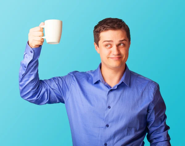 Casual man in shirt met cup op blauwe achtergrond. — Stockfoto