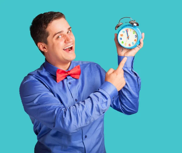 Casual man in shirt with alarm clock on blue background. — Stock Photo, Image