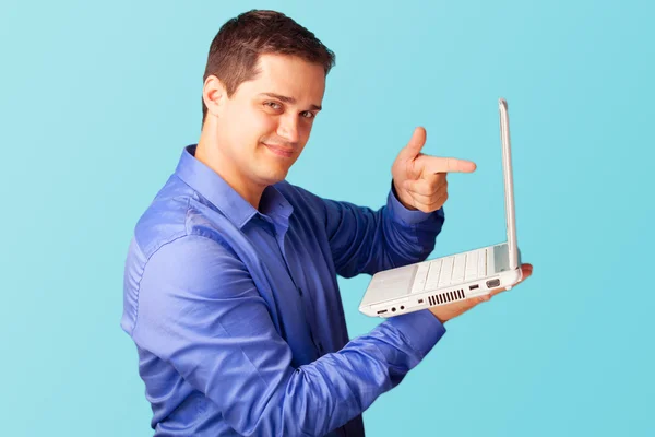 Bonito homem com laptop no fundo azul . — Fotografia de Stock