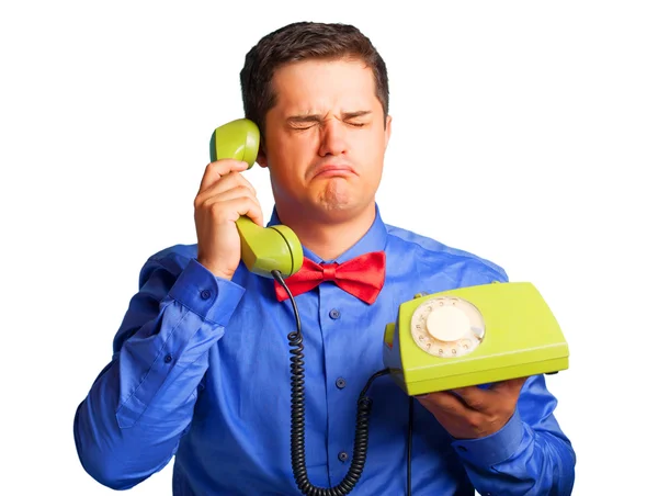 Bărbat surprins în cămașă cu telefon pe fundal albastru . — Fotografie, imagine de stoc